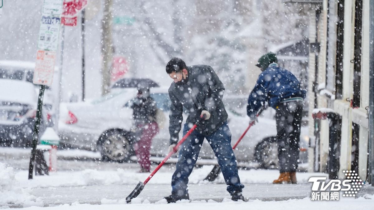 美國當地居民正在清理人行道上的積雪。(圖/達志影像美聯社)