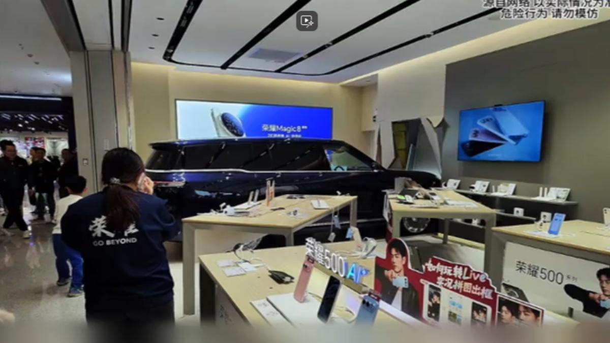 一輛展示汽車突然啟動並撞向正在營業中的手機店。（圖／網上影片）
