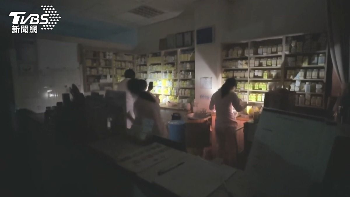 中醫診所藥劑師摸黑配藥。(記者 陳奇君攝)