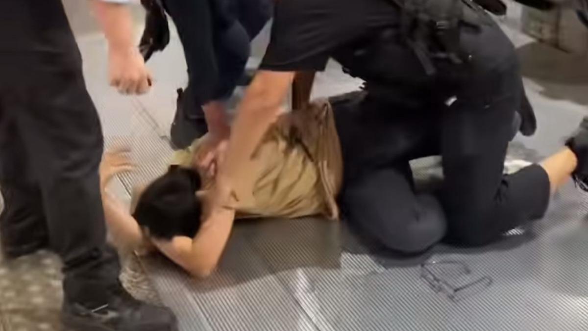 男子在北車捷運站咆嘯鬧事，遭警方噴辣椒水壓制在地。（圖／翻攝畫面）