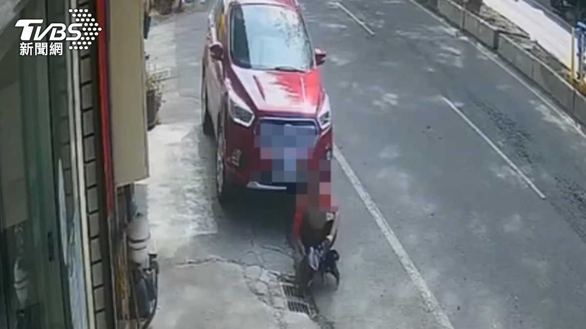 陳女在休旅車前玩狗。(圖/TVBS)