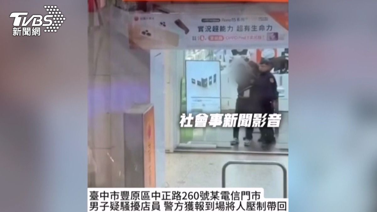 該名男子正準備在通訊行內鬧事,員警立即試圖將他帶離店內。(圖/翻攝社會事新聞影音)