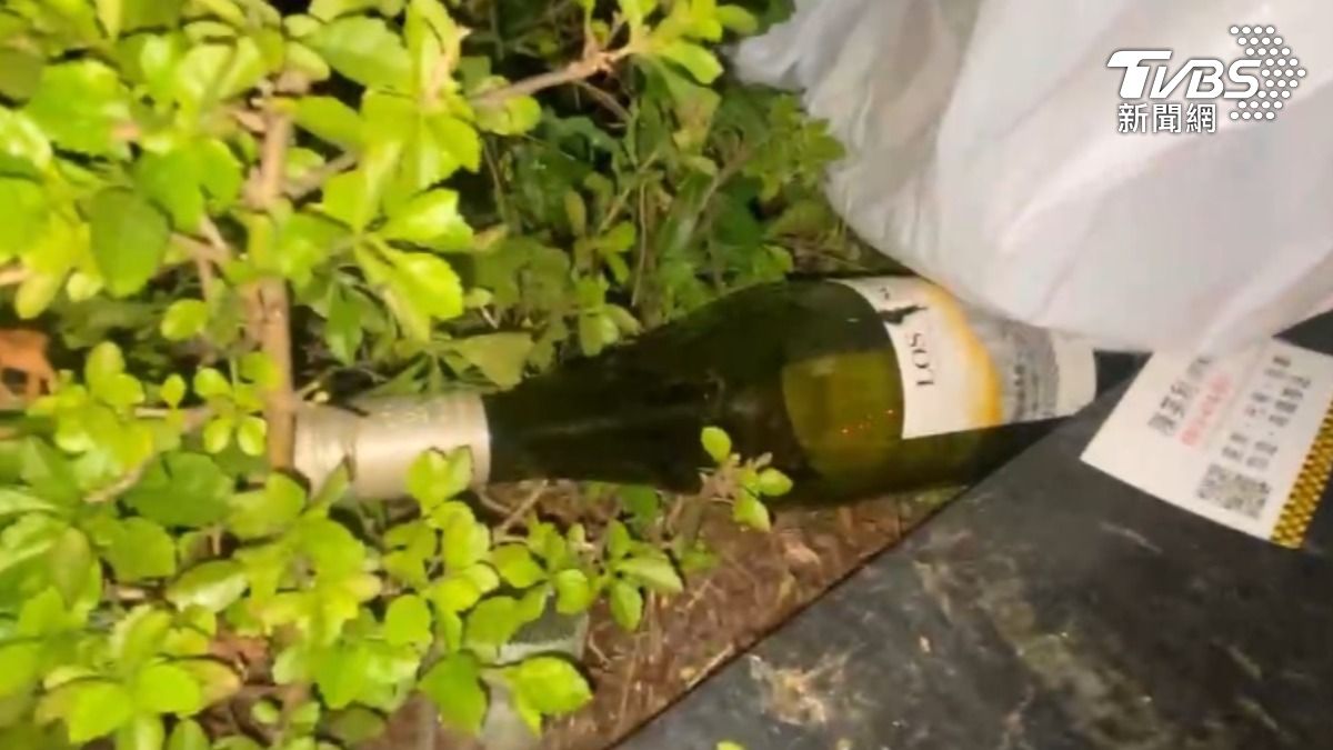 駕駛將酒瓶取出後,將其丟棄附近花圃,試圖銷毀酒駕證據。(圖/TVBS)