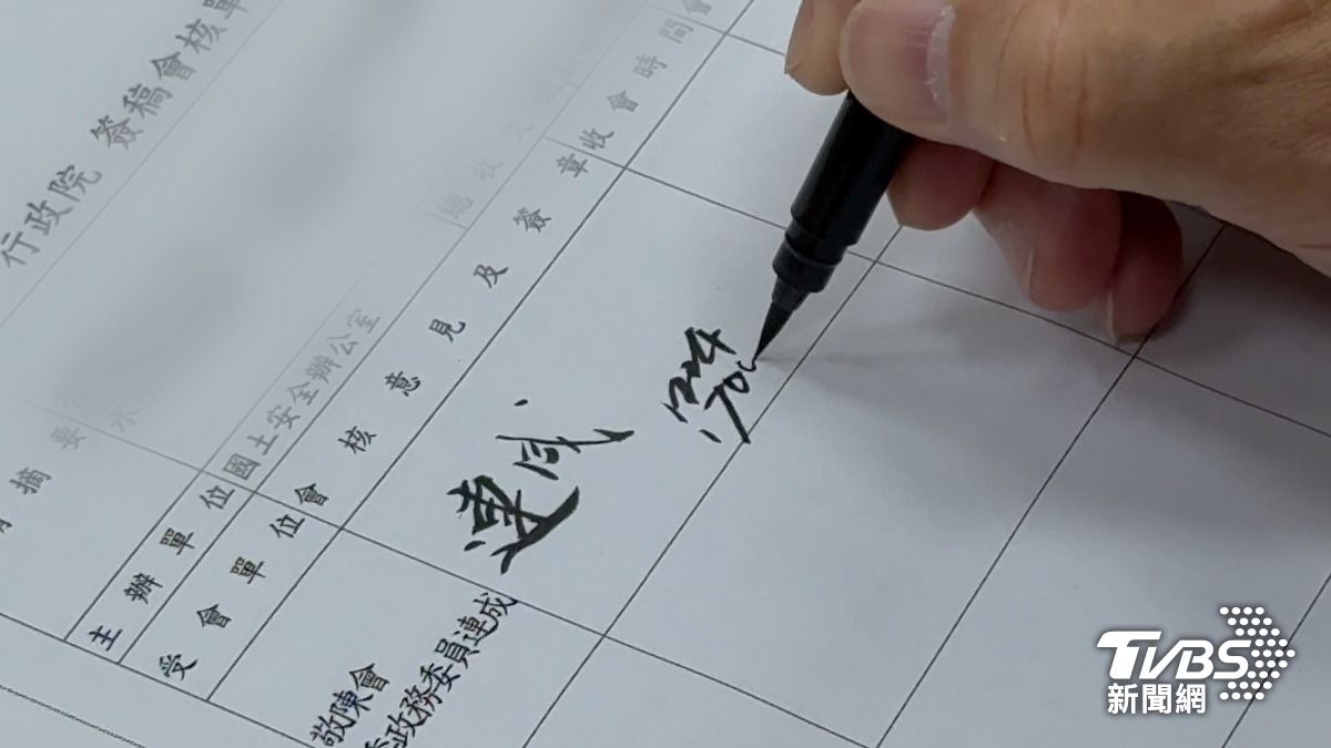 季連成用自來水毛筆批公文。災防法會議討論前他批公文、看自己記的筆記沉澱思緒。(圖/柯勝雄攝)
