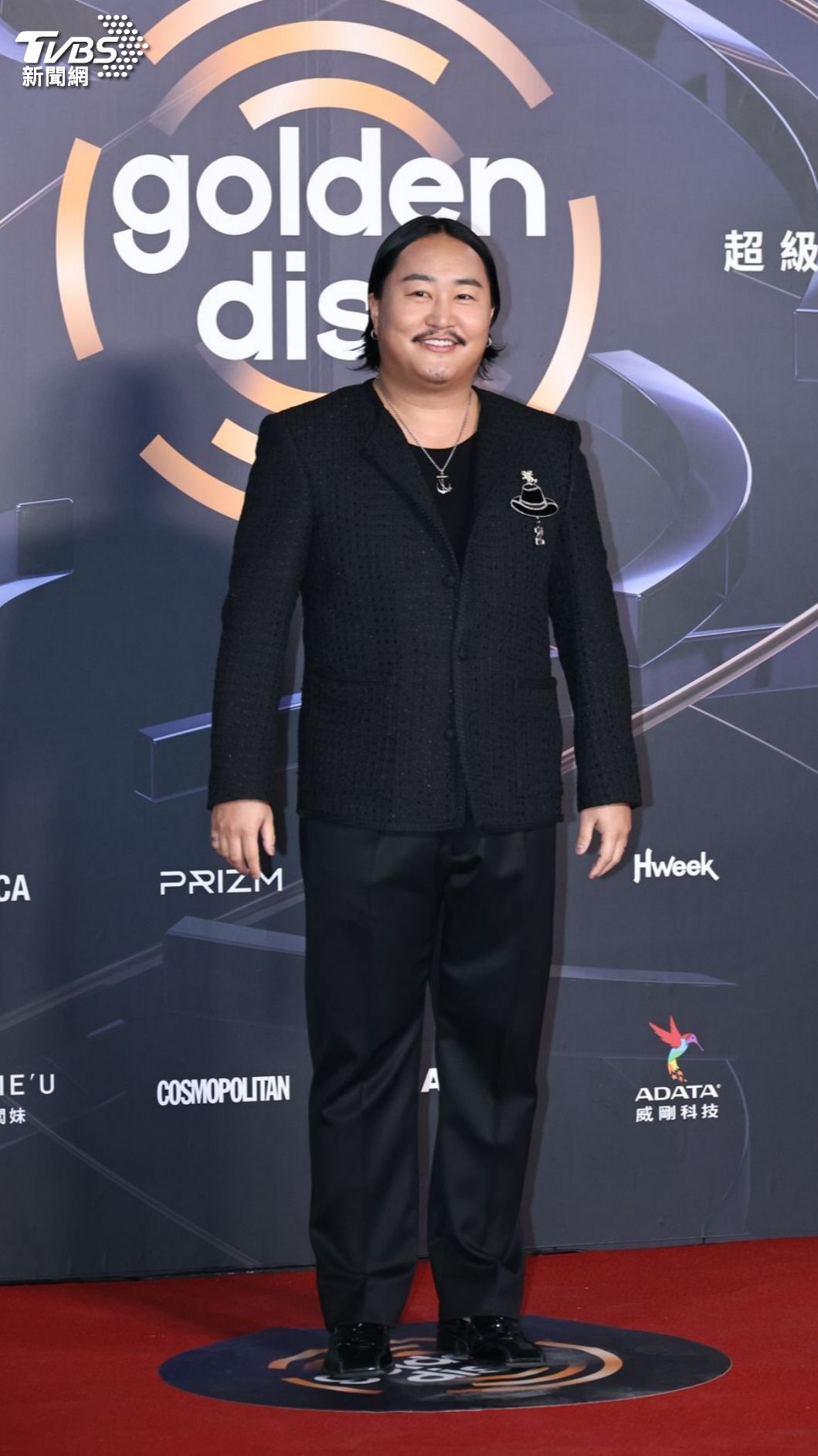 他身穿黑色格紋西裝外套，搭配標誌性的帽子胸針，為整體造型增添亮點，也讓正式感中多了幾分隨性感。（圖／張哲鳴攝）