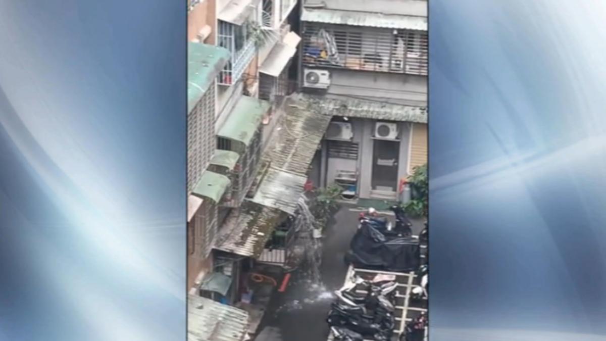 公寓洗水塔，水管不明原因垂在半空中，水柱狂噴如瀑布。 (圖／民眾提供)