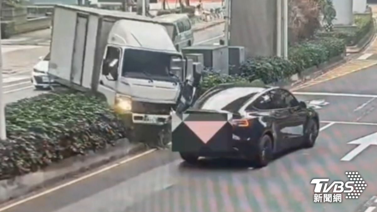 貨車失控衝分隔島，闖對向車道，險撞特斯拉。（圖／TVBS）