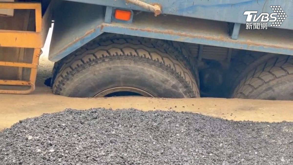 前一天塌陷的地方還在忙著施工填補，貨車進駐送進砂石，卻掉進新的大洞裡（圖／TVBS）