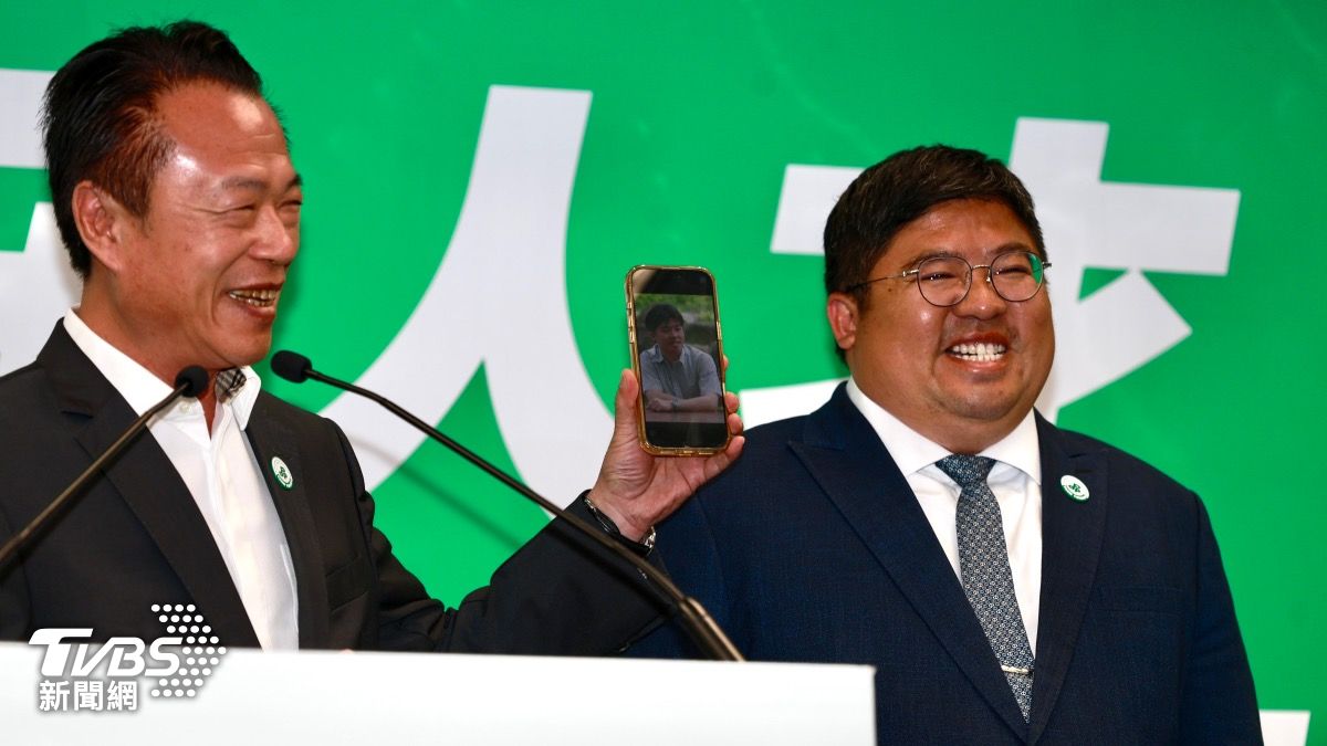 翁章梁(左)秀出蔡易餘的60公斤照。(圖/華子琛攝)