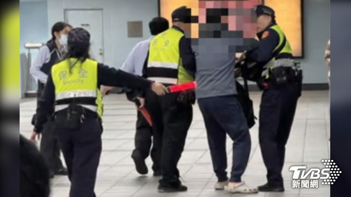 北捷南港展覽館站,灰衣男於車廂內亮剪刀發呆,捷警緊急將人帶離現場。(圖/TVBS)