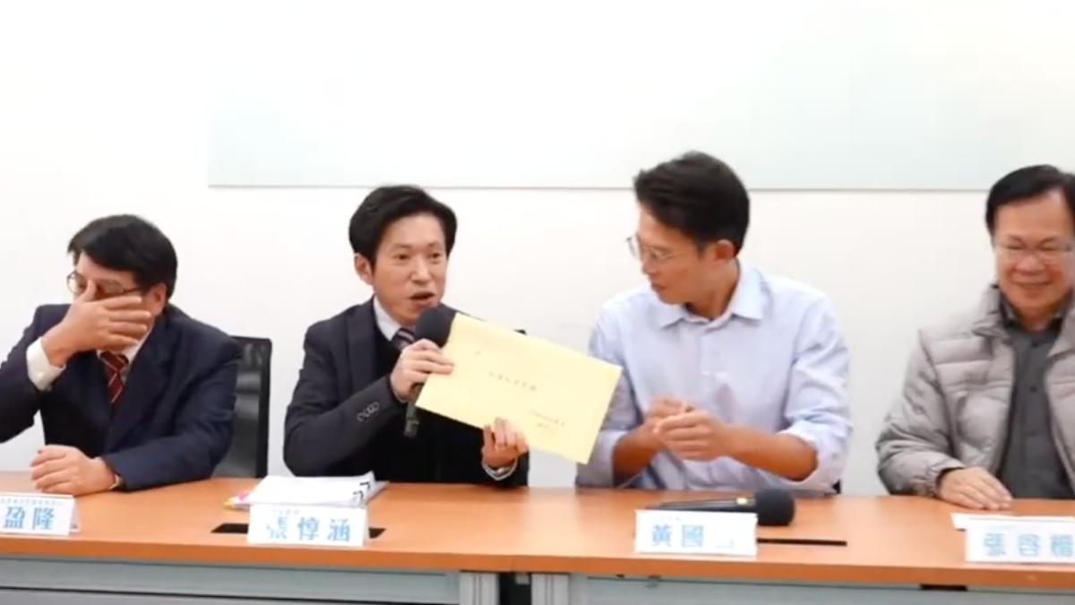 張惇涵送上「非機密文件」不在籍投票書面報告給黃國昌。(圖/翻攝自民眾之聲YT)
