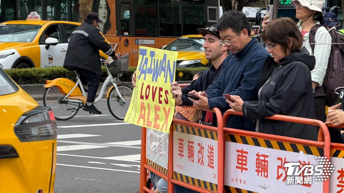 台北101下方擠滿人潮,外國民眾舉牌支持。(圖/蘇憶歡攝)