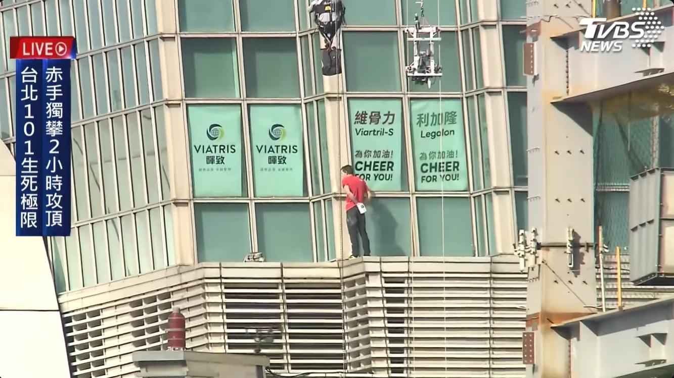 霍諾德攀爬的過程中意外出現多個品牌的應援海報。（圖／翻攝自TVBS NEWS YT）