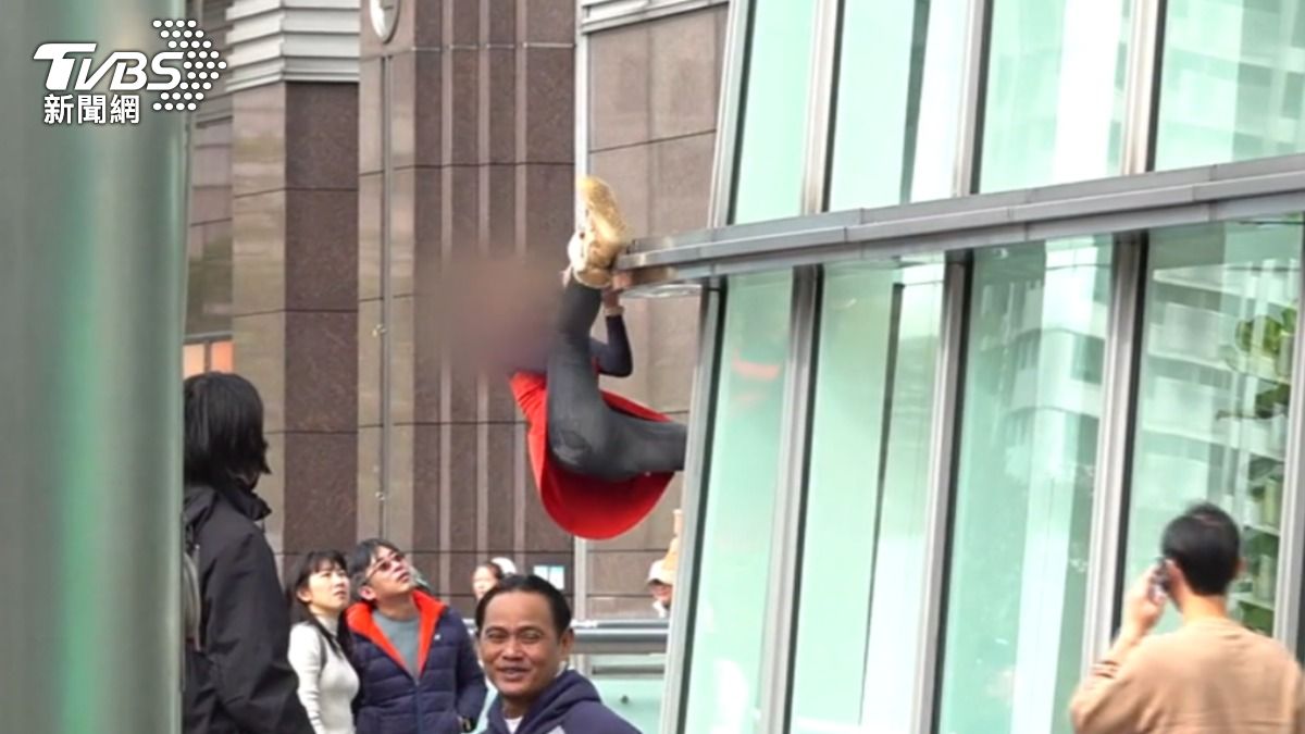 紅裙女違規攀爬101遭制止。(圖/TVBS)