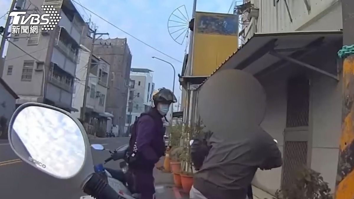 員警騎乘機車巡邏,轉頭時發現一名騎士正要騎出巷口,竟邊騎車邊吞雲吐霧,隨即上前盤查。(圖/TVBS)