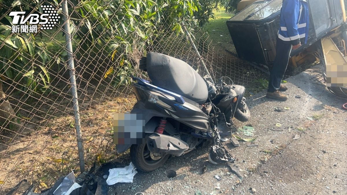 事故現場怪手翻覆橫躺在路旁，一旁還有被砸毀的摩托車，車頭嚴重凹陷，車殼零件四散各處。（圖／TVBS）