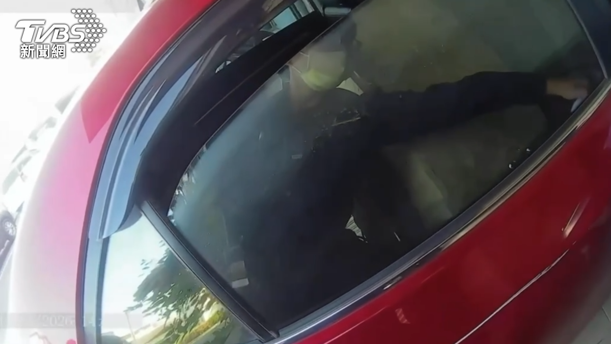 員警一手抬起洗手台，一邊幫忙指揮卡住的車子，最後還整個人側身，才讓車子順利脫困（圖／TVBS）