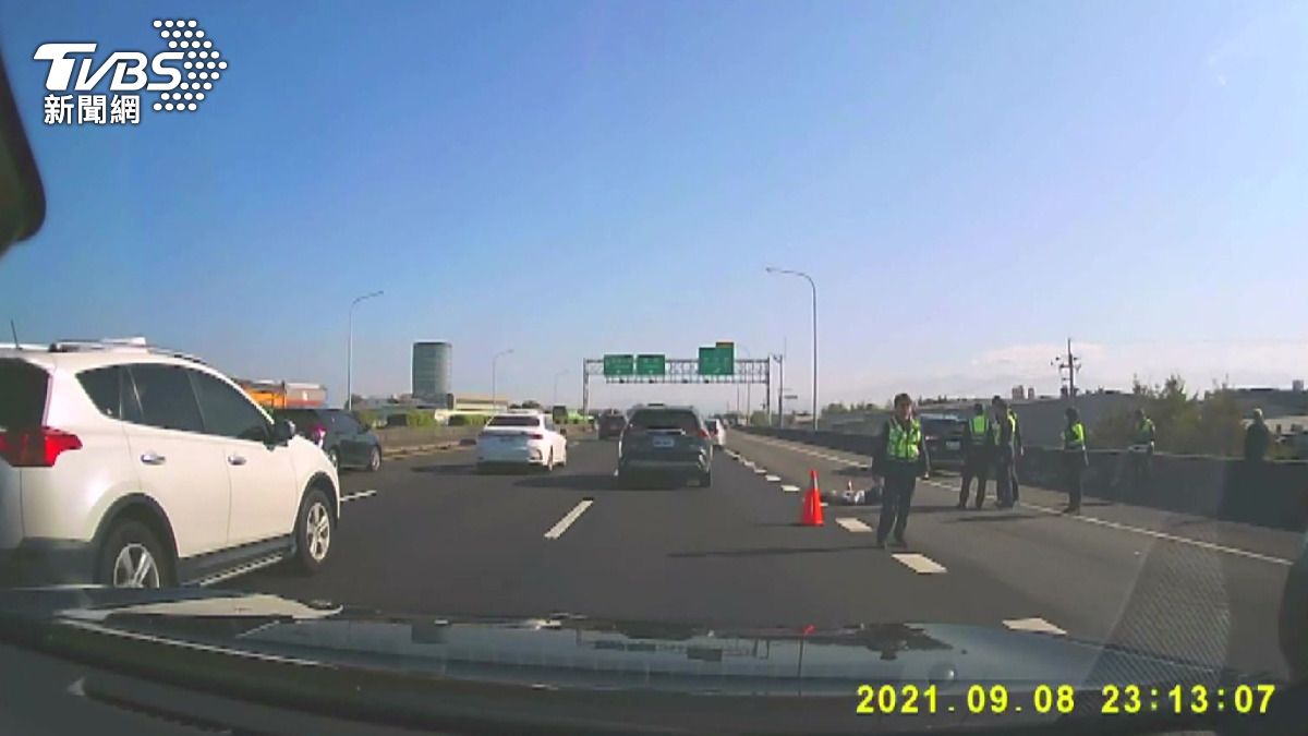張姓嫌犯躺在外側車道,雙腳已遭撞擊骨折。救護人員接觸時,他身上仍攜帶2把刀。(圖/警方提供)