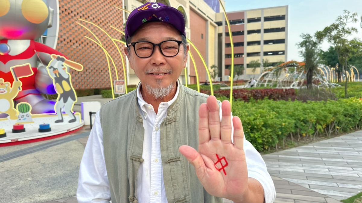 用紅筆在手掌心寫上「中」字於掌心哈一口氣。(圖/廖大乙提供)