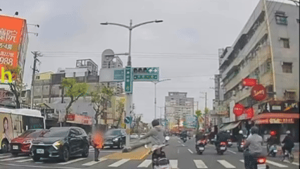 一名機車騎士發現前方有行動不便的行人受困於斑馬線中央，立即停車上前協助，牽著對方的手安全穿越馬路。（圖／翻攝Threads_mason_wsx）