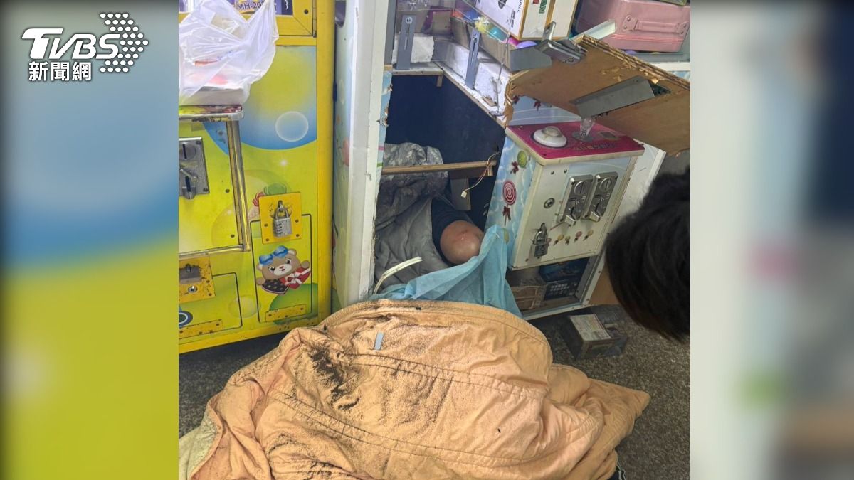 竊賊硬鑽娃娃機偷卡拉OK機組,沒想到整顆頭卡在取洞口。(圖/TVBS)