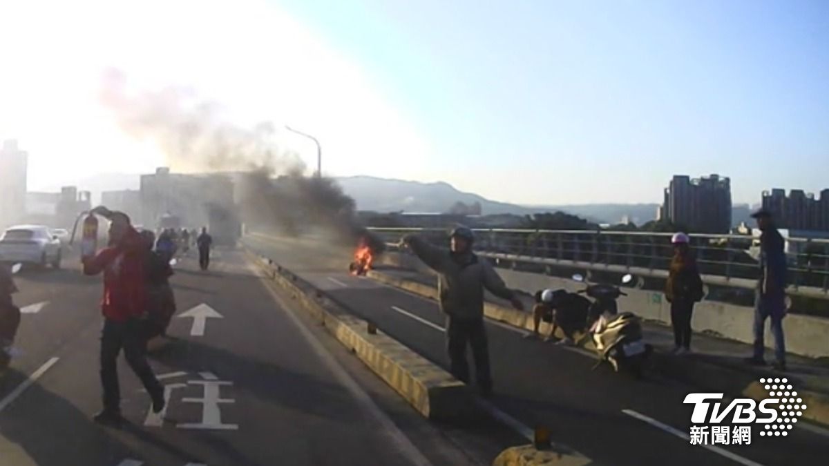 電動車雙載爆胎變火,目擊民眾幫攔車滅火。(圖/TVBS)
