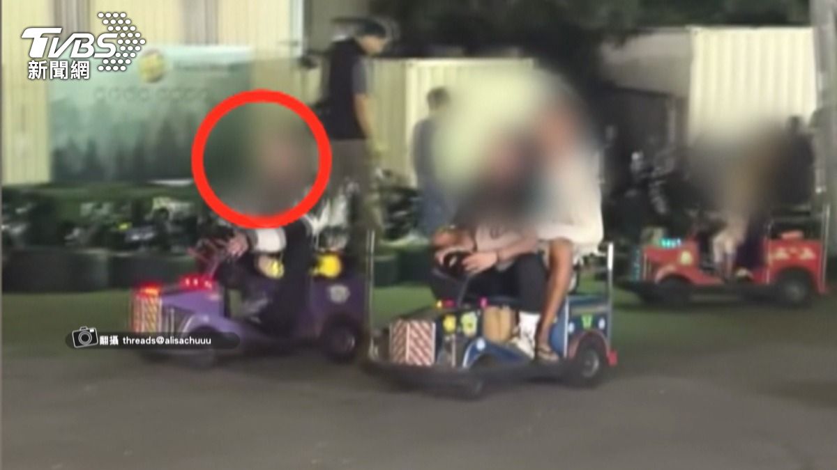 旱溪夜市的碰碰車攤位上,左手握著方向盤,右手拿著手機,手中還疑似夾著一根菸。(圖/TVBS)