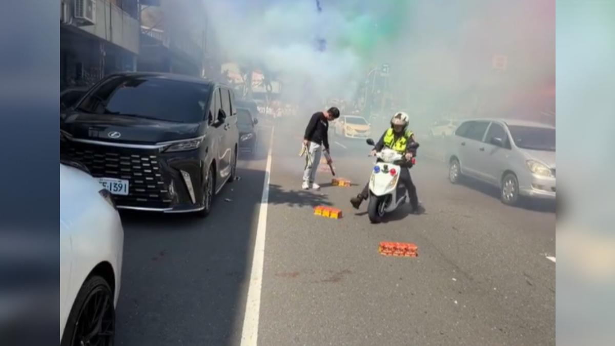 高雄旗山區一間廟宇13號舉行大型廟會,雖然依法申請路權,卻將鞭炮沿路放在車道中央,員警騎機車跟著沿路把鞭炮踢到路邊(圖/翻攝臉書@陳信亞追廟會)