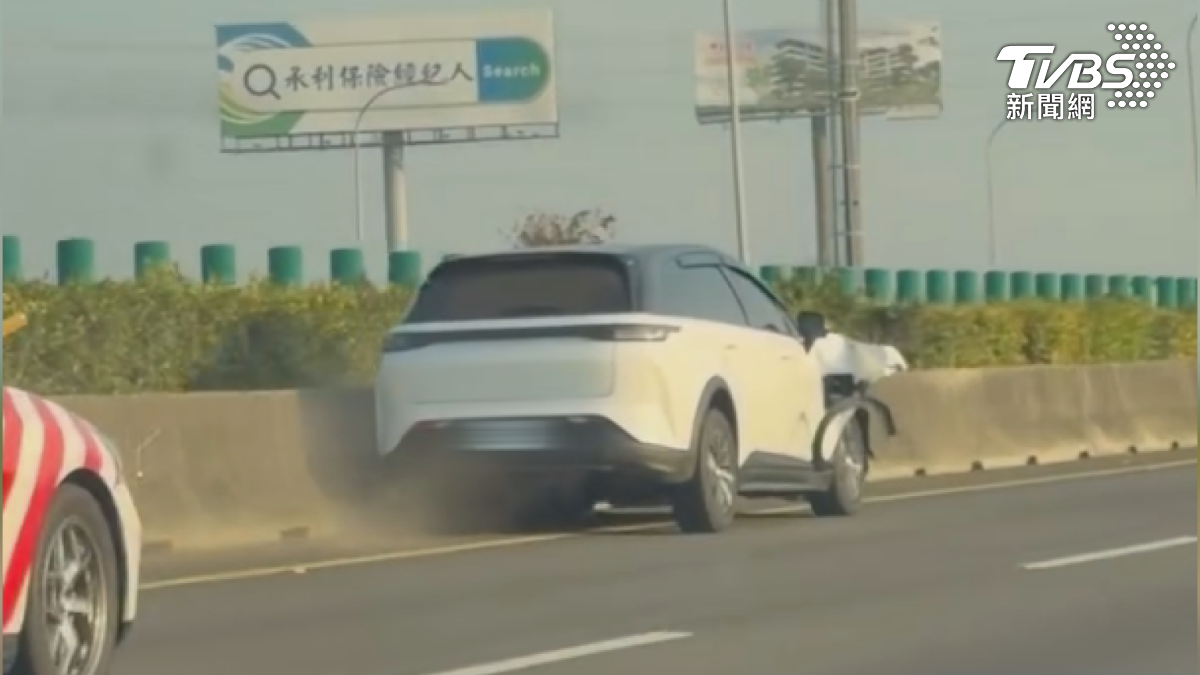 白色轎車撞上護欄還不停，車頭貼著執意前進，就算板金都翹起來了，整個車身還是黏在護欄上，駕駛已經昏迷（圖／民眾提供）