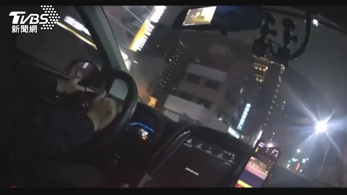 父子坐上警車後座,發動警車、鳴笛急駛,全力將男童送往醫院 。(圖/TVBS)