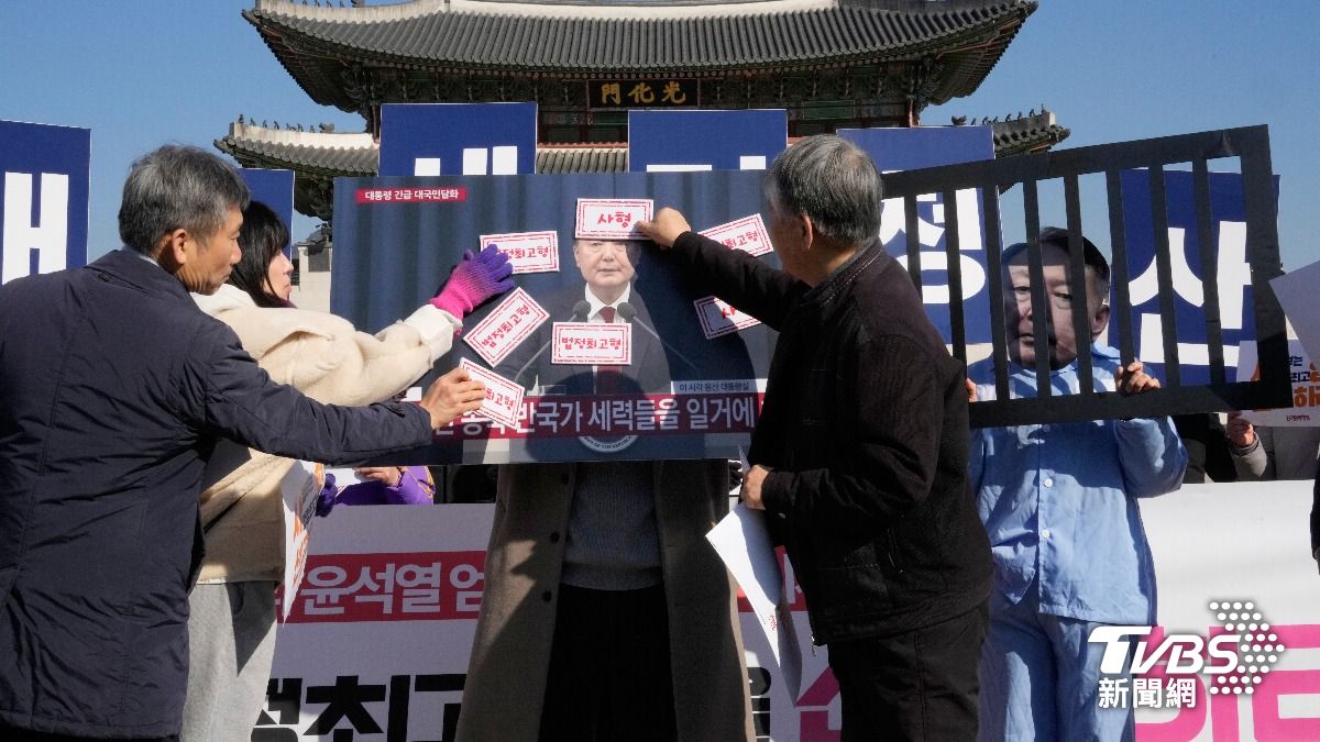 抗議者在法院宣判前舉行的新聞發布會上，將貼紙貼在韓國前總統尹錫烈的照片上。(圖／達志影像美聯社)