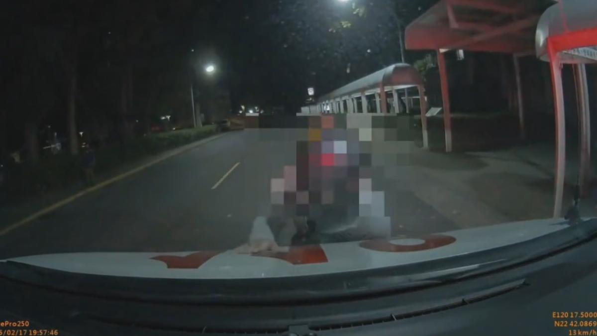 救護車進入院區內，男子衝向前，直接趴在救護車上面，按了喇叭也沒用，直到身旁的婦人趕緊拉走，迅速結束這場鬧劇（圖／翻攝爆料公社）
