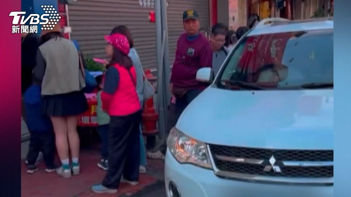 當地知名火雞肉飯店門口出現一輛白色車輛違規停放，被排隊人潮包圍住，戲稱在嘉義亂停車是會被民主包圍的。（圖／翻攝Threads @tommyhsu_0210）