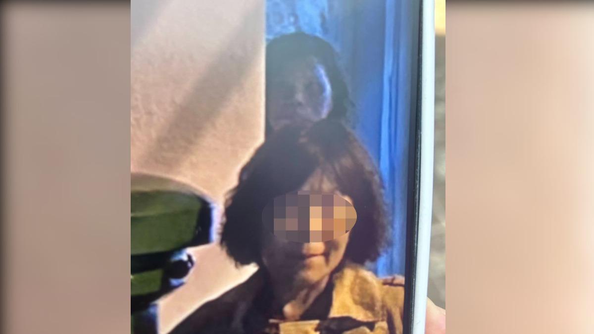 林太太在拍照時，身後多出一名詭異老婦的臉。（圖／恆春城隍廟提供）