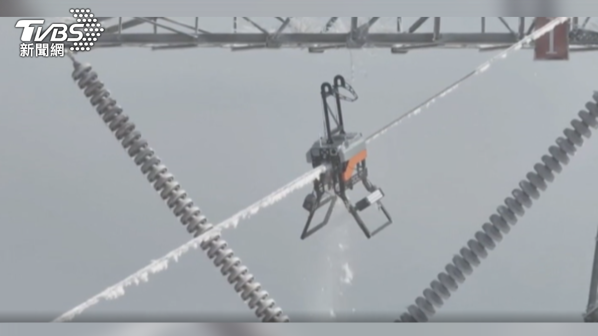 大陸安徽電力公司工程師放飛無人機,將除冰機器人放上電纜,整條20公尺長的電纜,在1分鐘內就能完全除冰。(圖/大陸央視)
