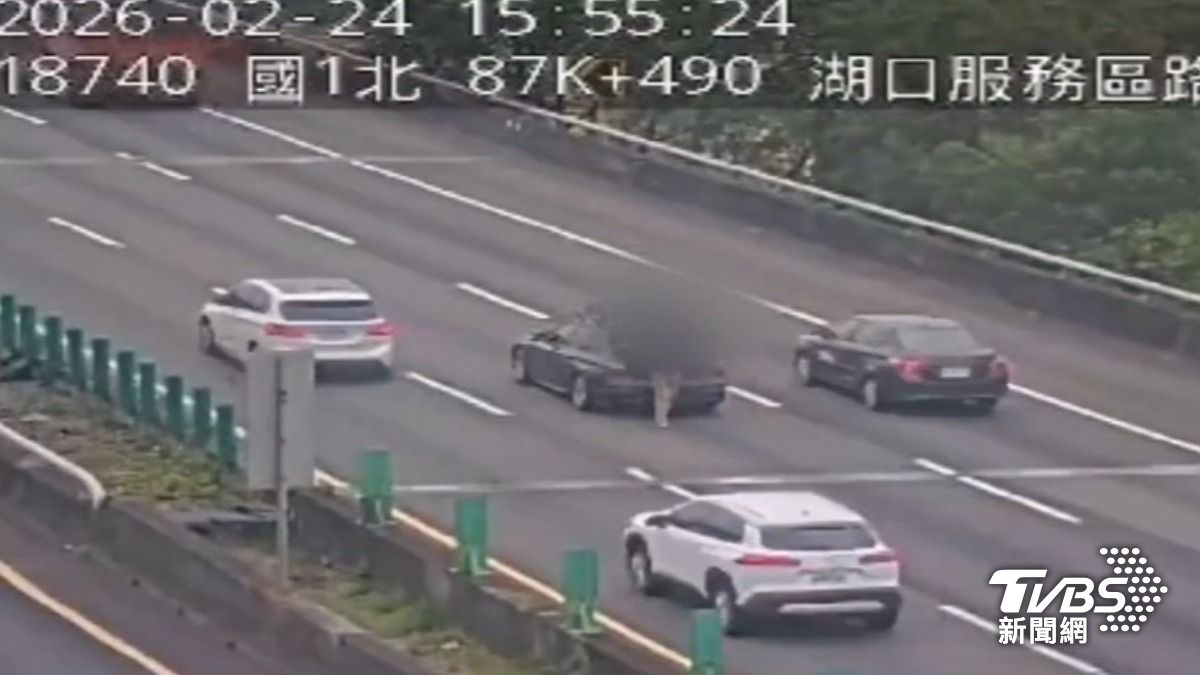 轎車拋錨國道中線,男駕駛「站車後」滑手機。(圖/TVBS)
