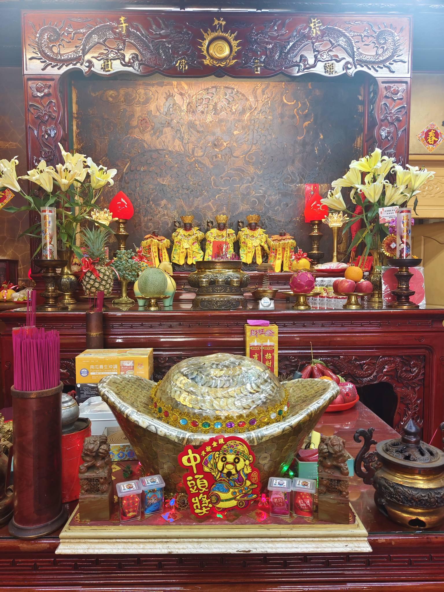 男子摸了店內的大金元寶,並向觀音祈願後,順利抱回700萬。(圖/翻攝自臉書「高雄南海紫竹寺 & 大福興彩券行」)