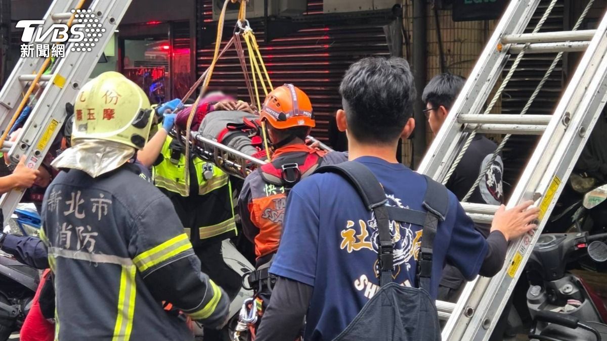 婦人墜樓後卡在遮雨棚上，警消到場救援。（圖／TVBS）