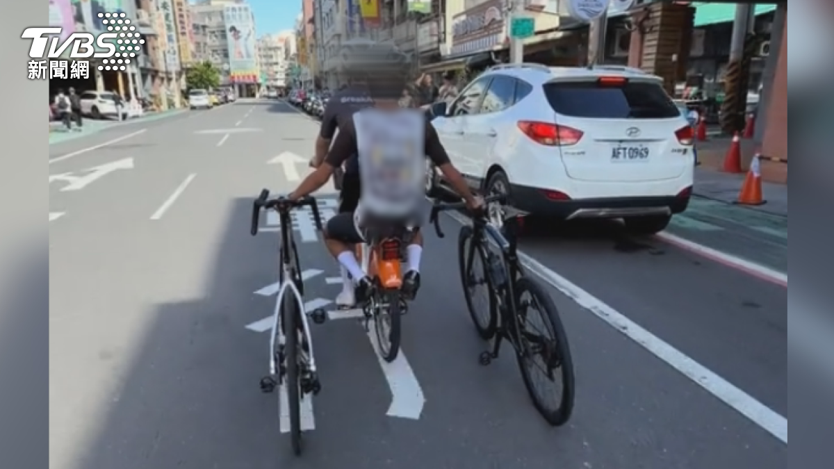 高雄鼓山,出現誇張一幕,兩個人擠在一輛UBike 電輔車上,後座男生還直接坐在脆弱的電池殼上,雙手各抓一輛自行車併行(圖/翻攝自抖音)