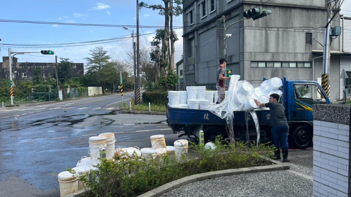 小貨車載滿桶裝的濃縮液態肥料，疑似未綑綁牢固，轉彎時掉落撒出。（圖／TVBS）