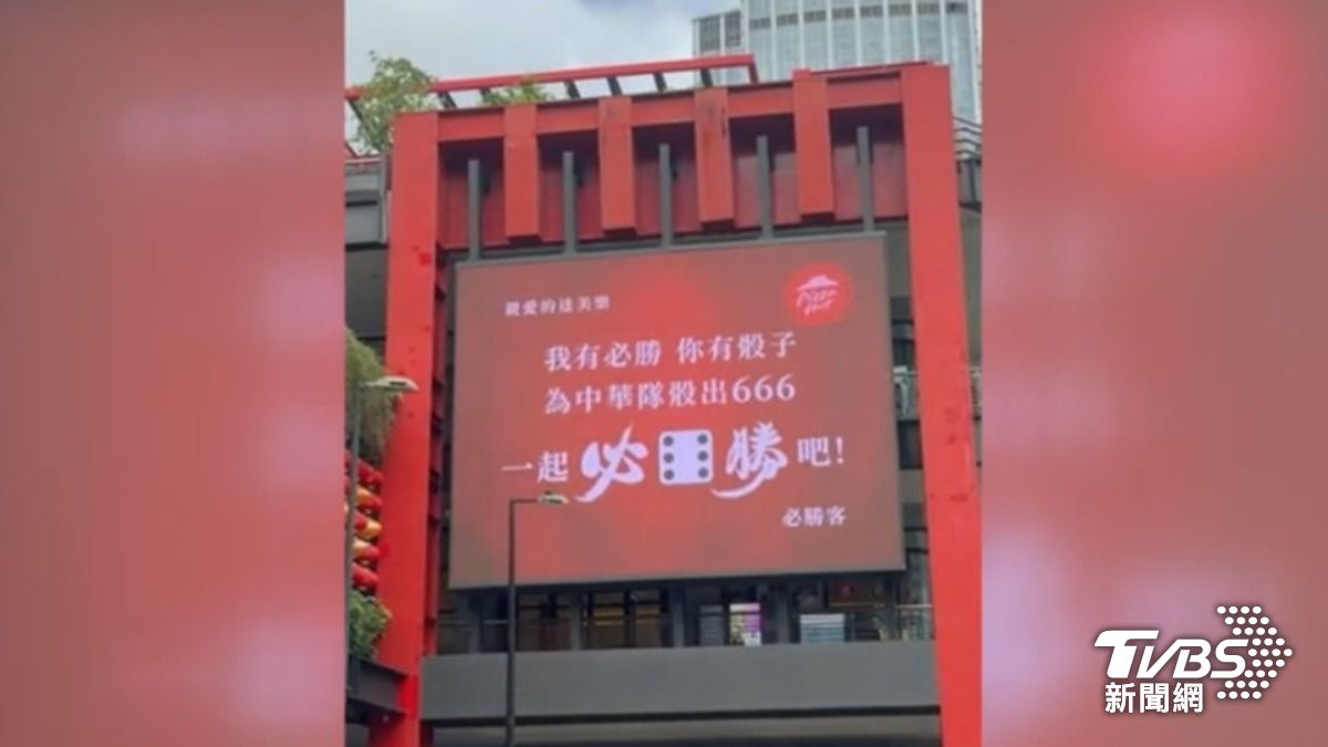 必勝客在台北信義區掛出超大廣告,直接點名達美樂,喊話「為中華隊骰出666」。(圖片來源/業者)