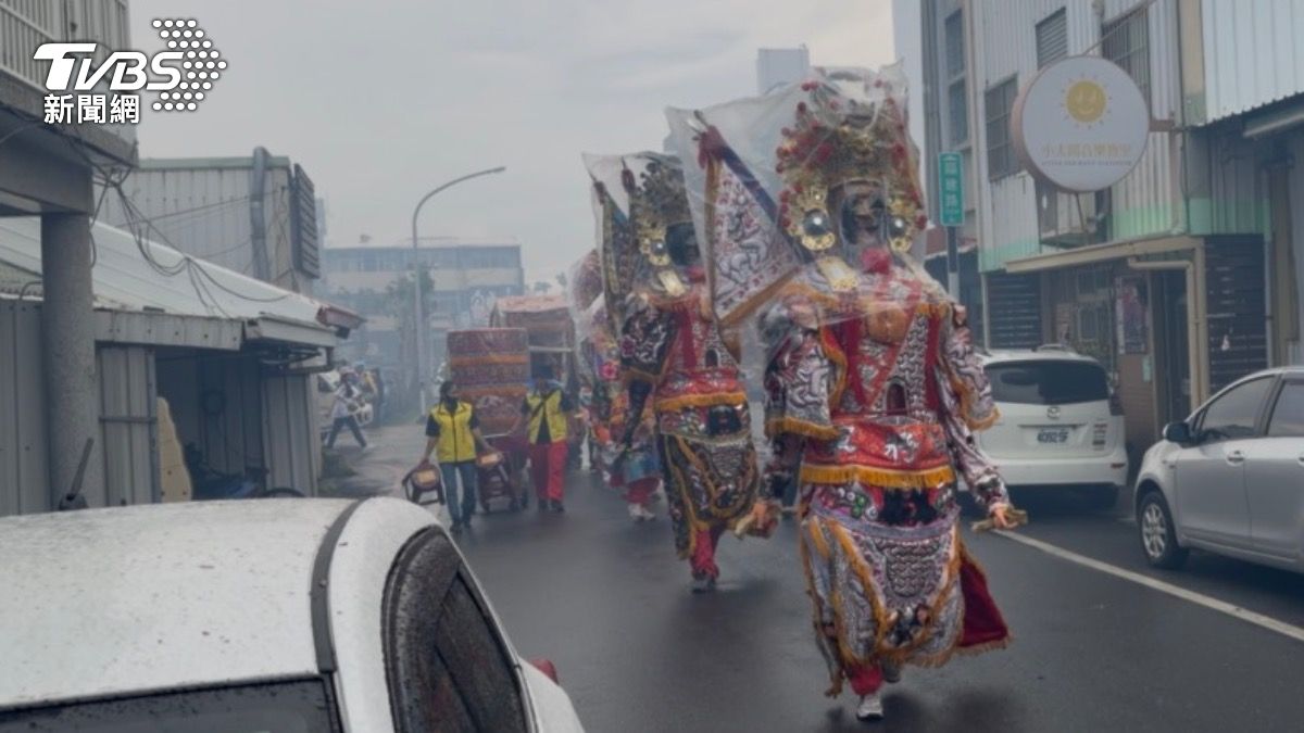 雨中遶境的城隍廟隊伍,黑白無常七爺、八爺神尊全套上大塑膠袋,難免威風盡失,有些可惜。(圖/TVBS)