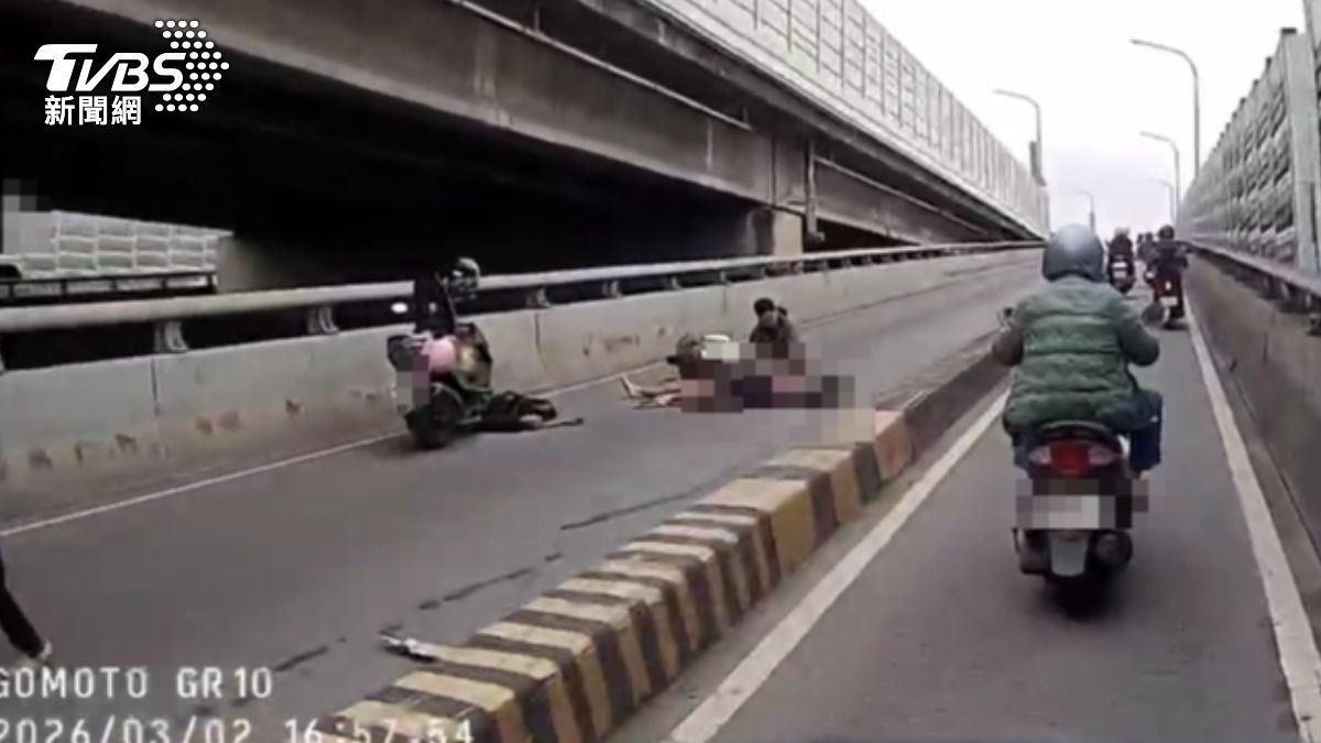 無照男自撞分隔島,彈飛摔進車道,滿臉血倒地,命危送醫。(圖/TVBS)