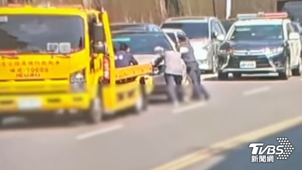 車主怒槓拖吊業者,警暖心幫推車解圍。(圖/TVBS)