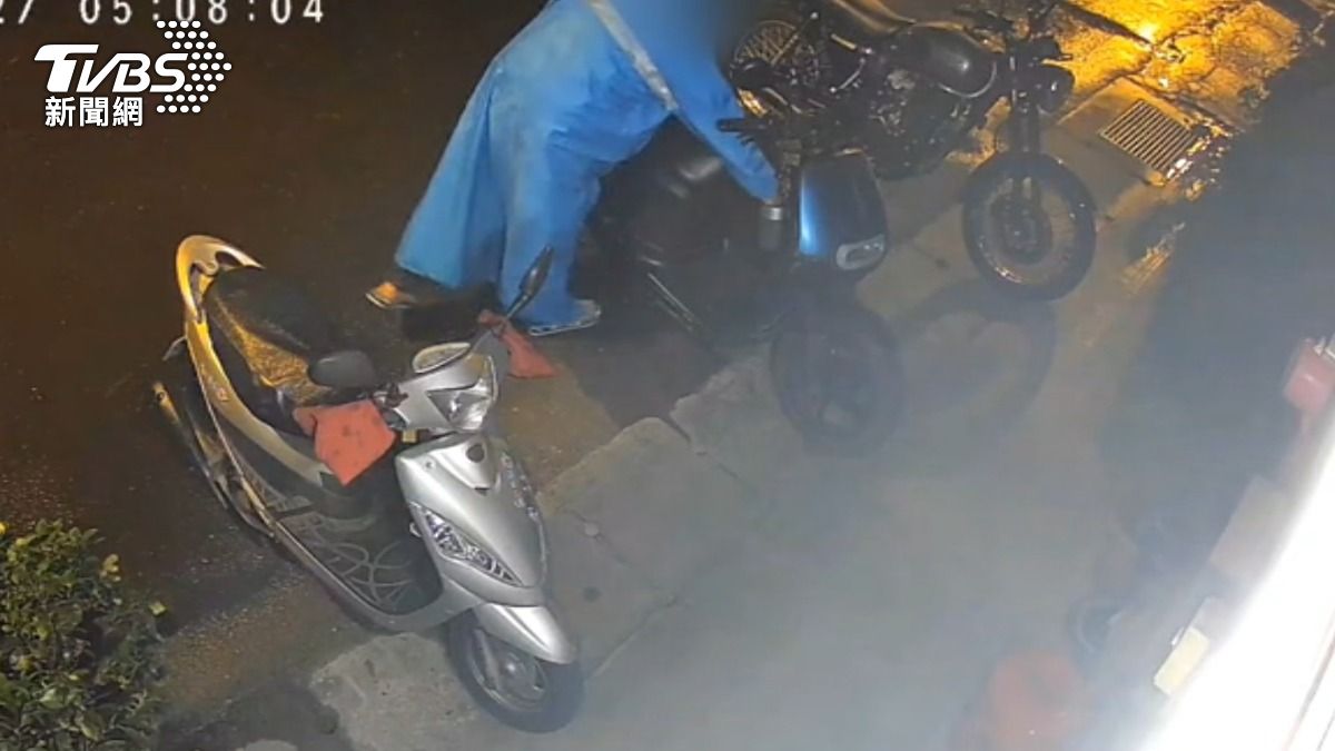 雨衣男翻找住戶的機車前置物箱。（圖／TVBS）