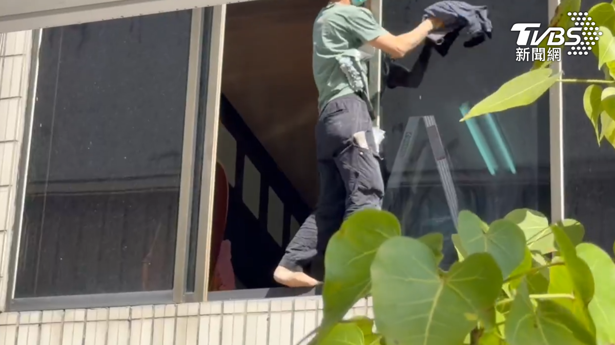 為了擦大片門窗,這名男子居然又踏上窗台,這時整個人已經都露在外頭,除了一手擦窗,一手緊抓窗角(圖/TVBS)