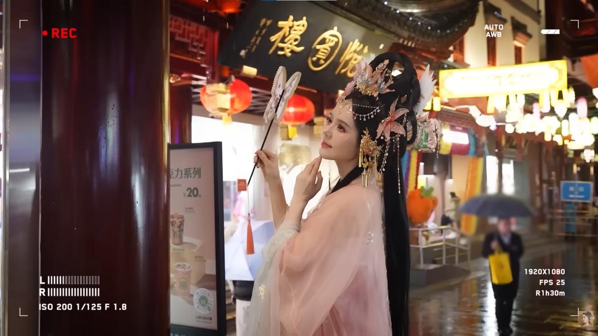 韓佳人換上粉色中式服裝,頭髮搭配頭飾做出華麗造型,在雨中進行拍攝。(圖/翻攝自YT@자유부인 한가인)