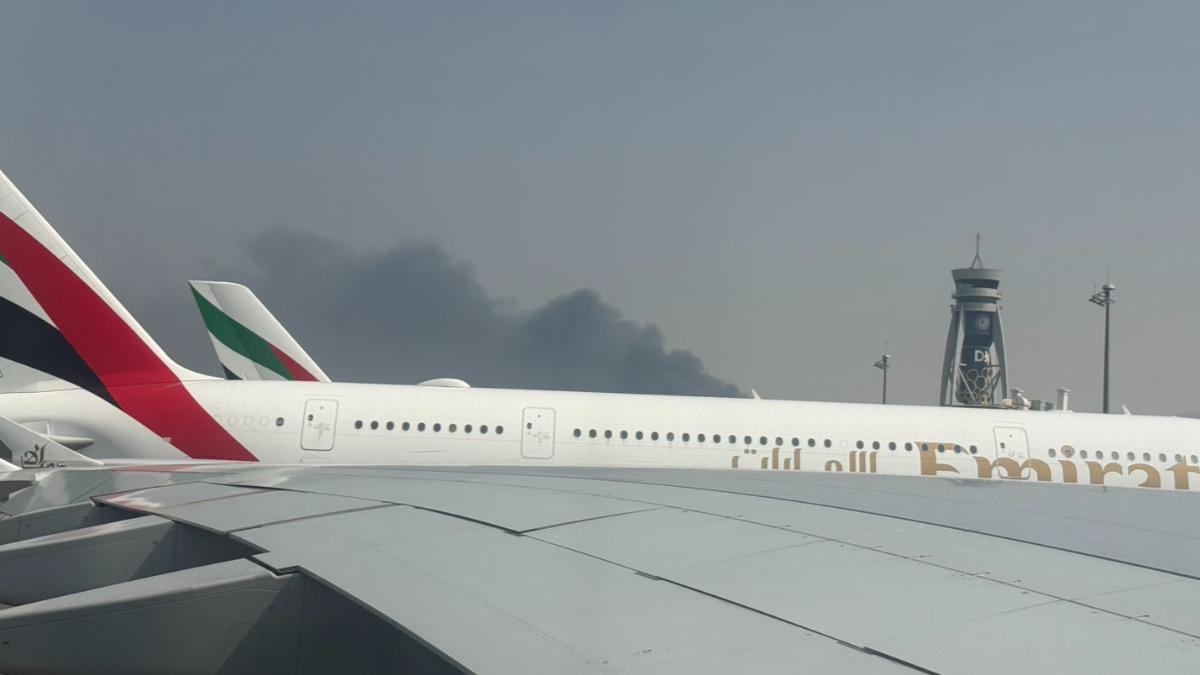 杜拜國際機場16號清晨傳出無人機攻擊,民眾在飛機上拍下機場竄出黑煙。(圖/民眾提供)