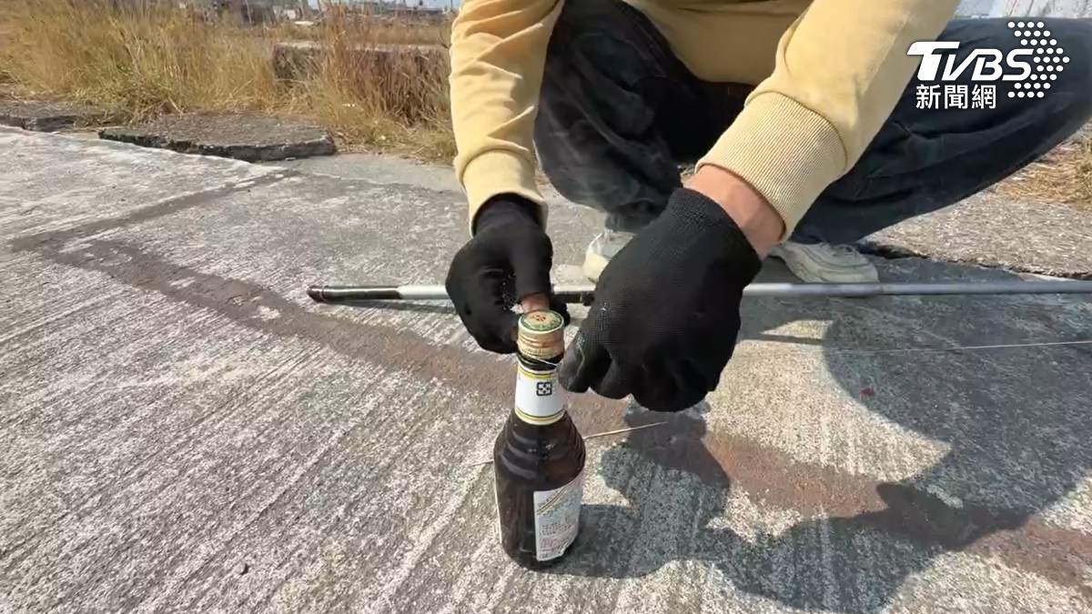 釣客示範將瓶子綁在釣竿上作為提示音,當魚上鉤時坐在另一邊也能聽到信號。(圖/TVBS)