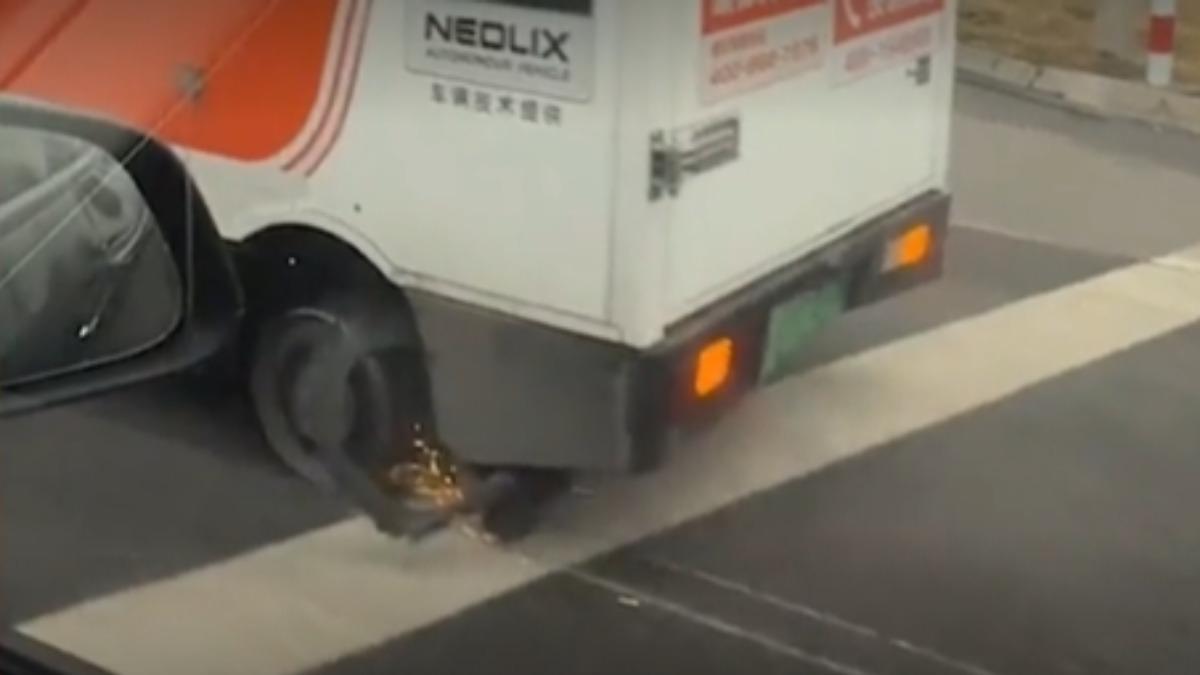 山東一輛無人快遞車爆胎還持續往前開，輪框摩擦地面火光四濺。（圖／百度）
